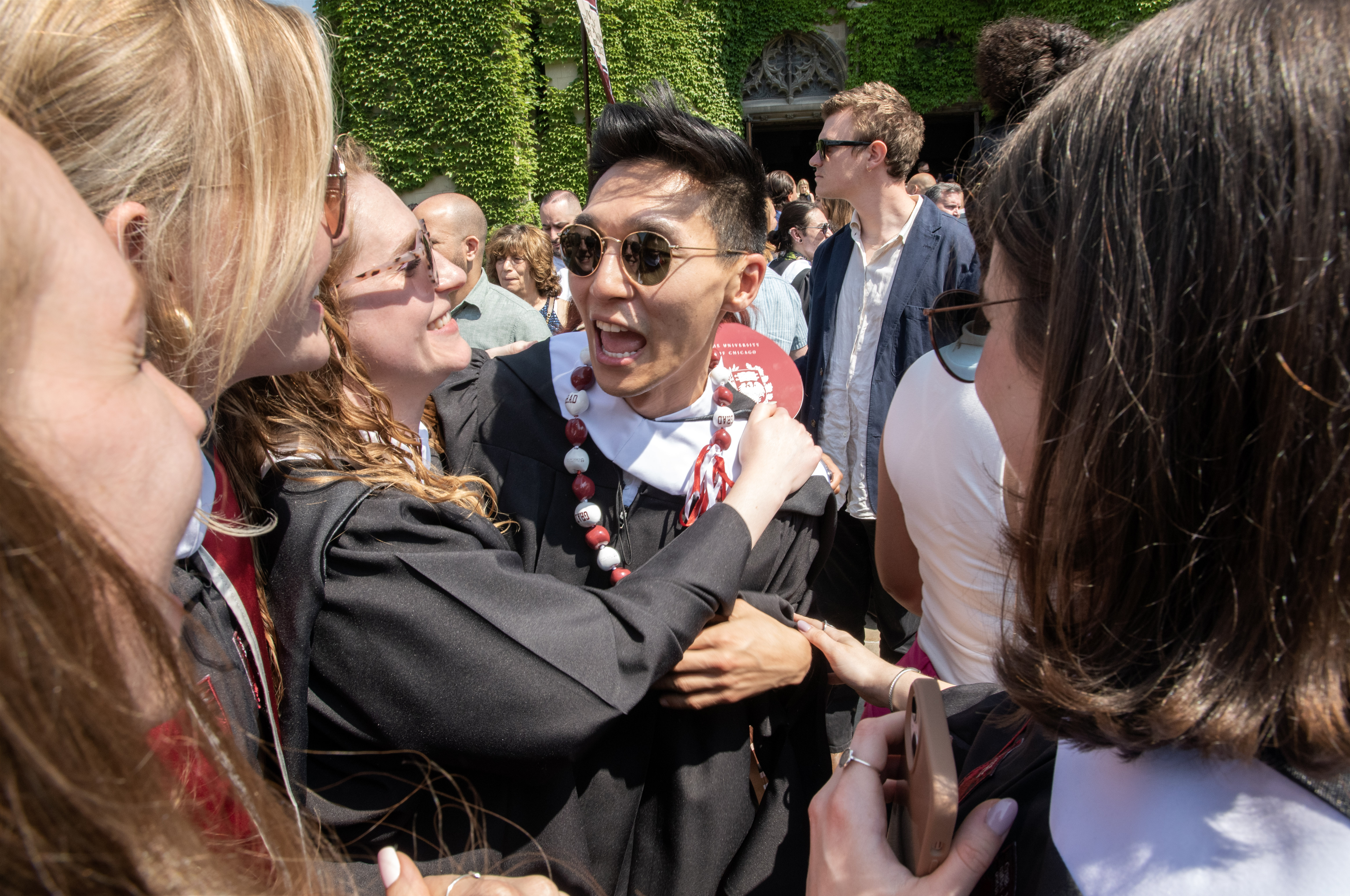 image of an excited male hugging a woman in graduation robes
